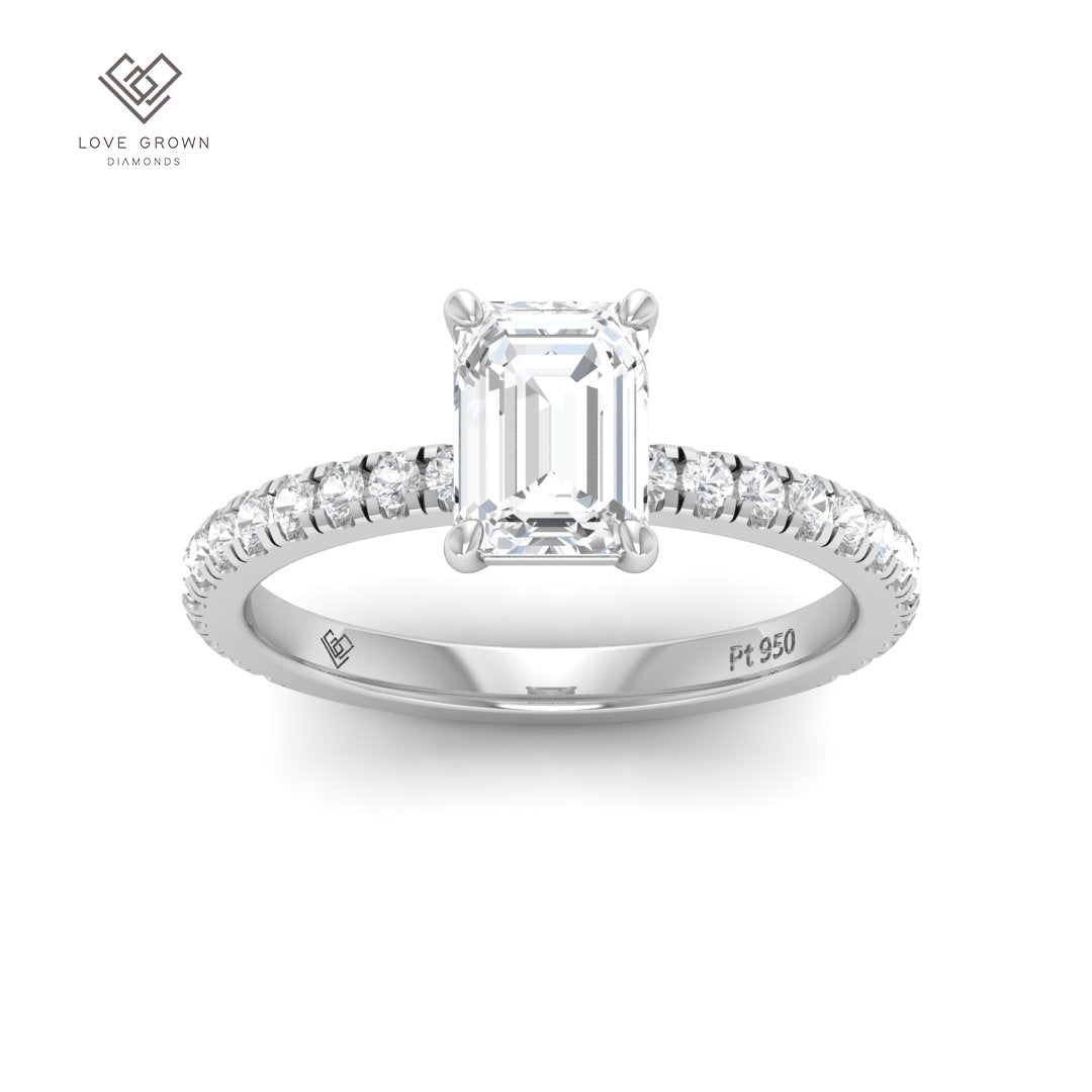 Emerald cut solitaire diamond ring with diamond band in platinum setting.